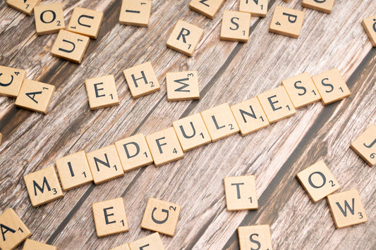 scrabble tiles spelling the word mindfulness on a wooden surface