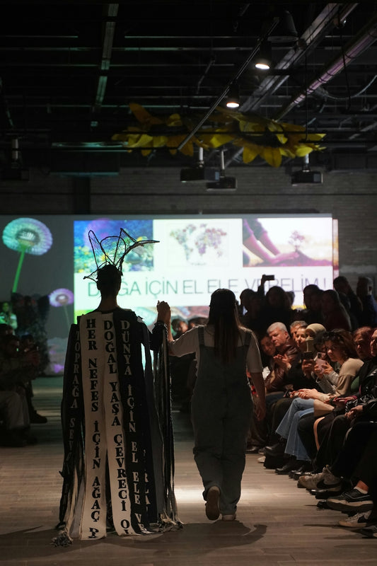 A fashion model walks the runway at an event.