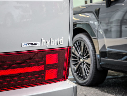 A hybrid vehicle's rear is partially visible.