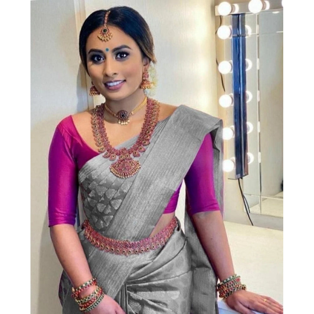 Woman in a gray saree with a pink blouse.