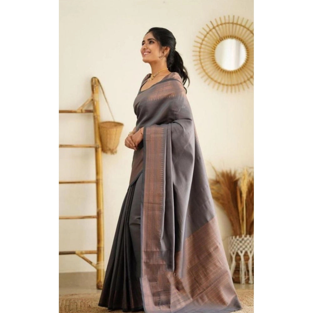Woman wearing a gray saree with a brown border