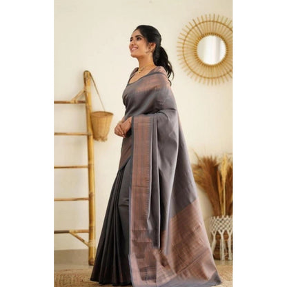 Woman wearing a gray saree with a brown border
