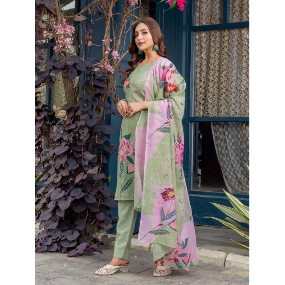 Woman in a floral outfit standing in front of a decorative door with plants.