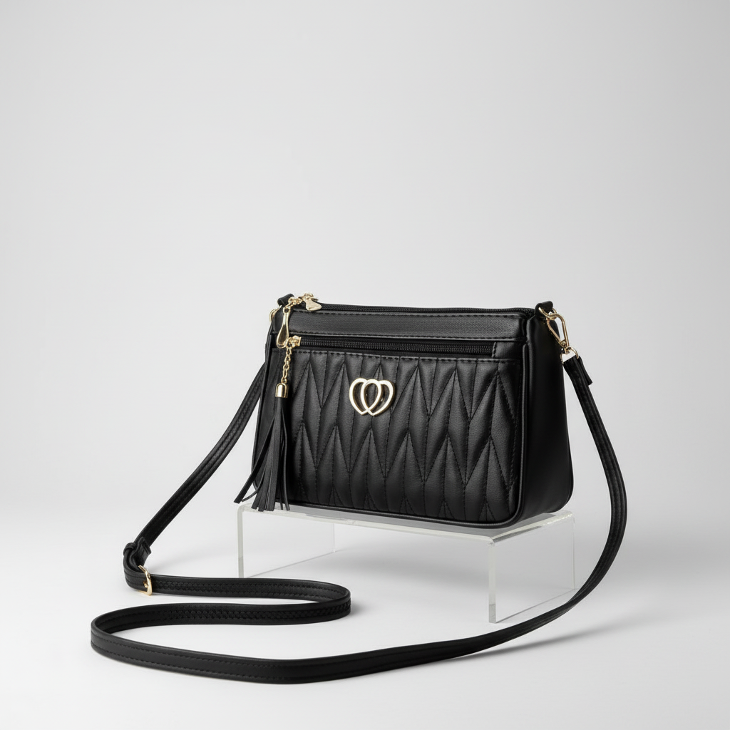 Black quilted handbag with a heart-shaped clasp on a light background